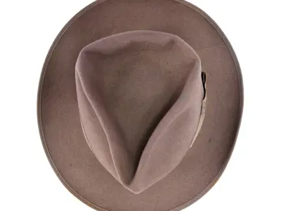 Fedora made of grey suede with a matching satin band. The brim is flat and broad and the crown has a teardrop shaped indent.