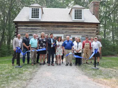 Warden Kevin Marriott officially cuts the ribbon on the restored Canatara Cabin alongside MP Marilyn Gladu, Lambton Heritage Museum Curator/Supervisor Dana Thorne, Lambton Shores Mayor Doug Cook, and the many community members, tradespeople, donors, and supporters whose dedication and generosity made this six-year restoration project possible.