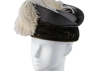 Black velvet hat decorated with white ostrich feather. 