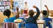 Shot of an unrecognizable group of children sitting in their school classroom and raising their hands to answer a question